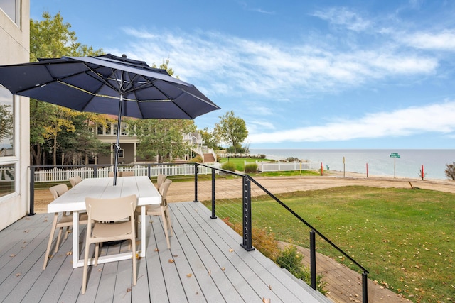 wooden terrace with a yard and a water view