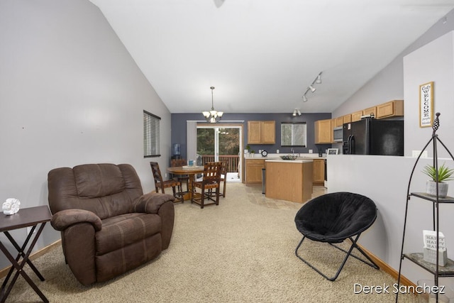 living room featuring light carpet, rail lighting, vaulted ceiling, and a notable chandelier