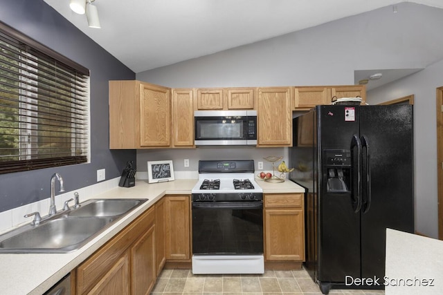 kitchen with sink, stainless steel appliances, and vaulted ceiling