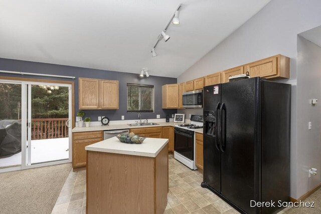 kitchen with a center island, lofted ceiling, sink, light brown cabinetry, and stainless steel appliances