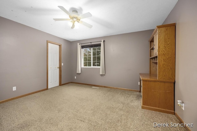 carpeted spare room with ceiling fan