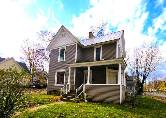 view of front of house with covered porch and a front lawn