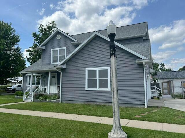 view of front of house with covered porch and a front lawn