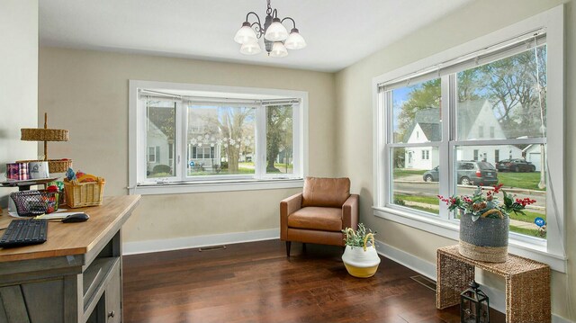 living area with a notable chandelier and dark wood-type flooring