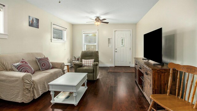 living room featuring ceiling fan and dark hardwood / wood-style floors