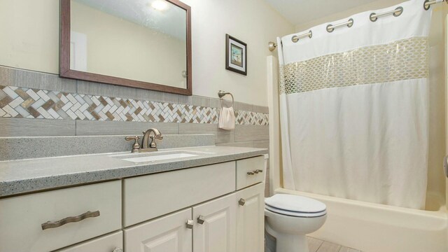 full bathroom featuring shower / bath combo with shower curtain, vanity, and toilet