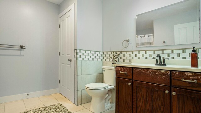 bathroom with tile patterned flooring, vanity, toilet, and tile walls