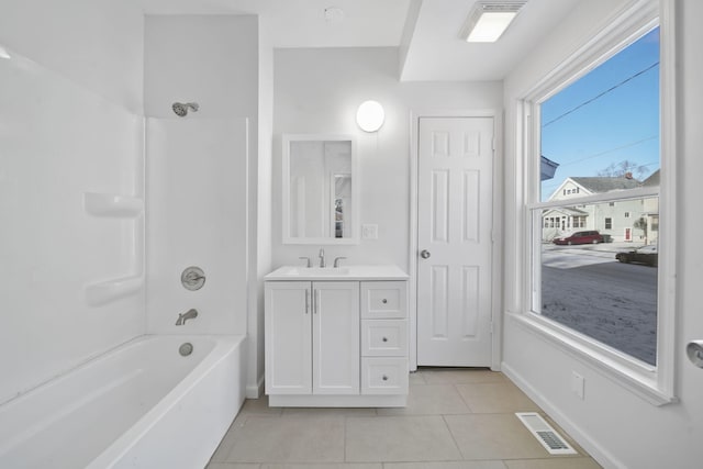 bathroom featuring tile patterned flooring, vanity, and  shower combination