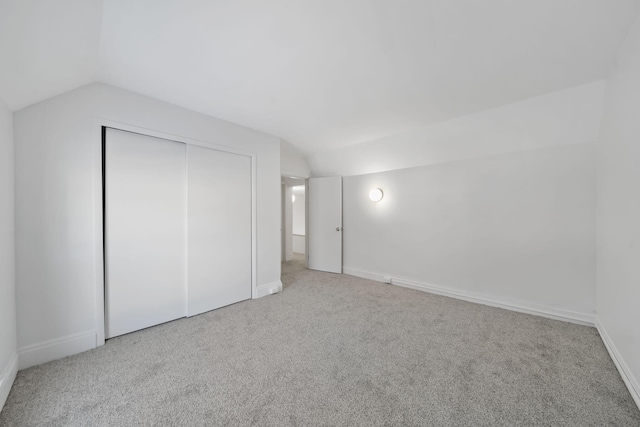 bonus room with light carpet and vaulted ceiling