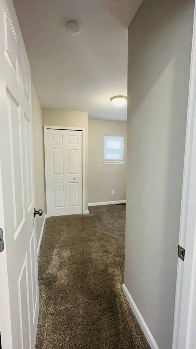 hallway featuring dark carpet