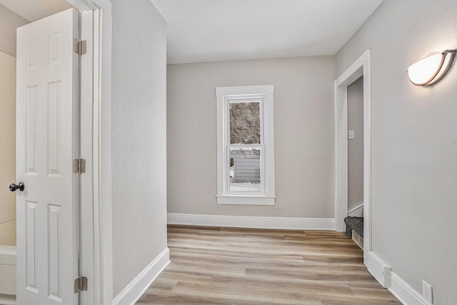 hallway with light hardwood / wood-style floors and a healthy amount of sunlight