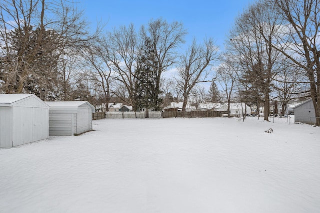 yard covered in snow with a shed