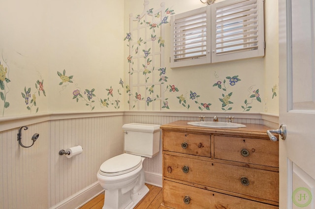 bathroom with hardwood / wood-style flooring, vanity, and toilet