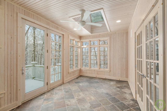 unfurnished sunroom with plenty of natural light, wooden ceiling, ceiling fan, and french doors