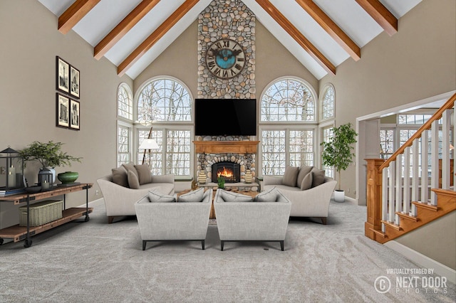 living room with beamed ceiling, light colored carpet, a fireplace, and a wealth of natural light