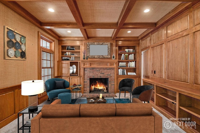 living room featuring beam ceiling, a brick fireplace, built in shelves, and coffered ceiling