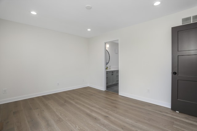 interior space with light hardwood / wood-style floors, ensuite bath, and sink