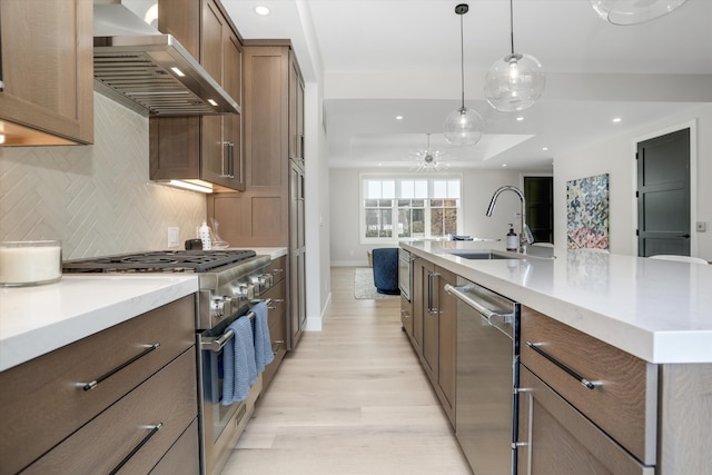 kitchen featuring pendant lighting, backsplash, a spacious island, wall chimney exhaust hood, and appliances with stainless steel finishes