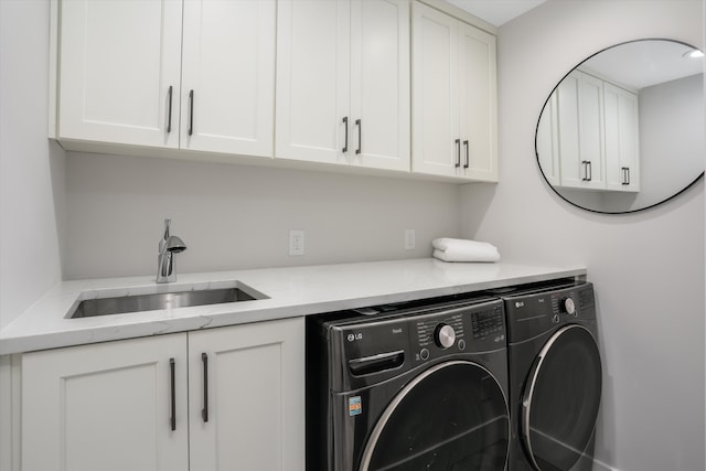 laundry room featuring cabinets, sink, and washing machine and clothes dryer