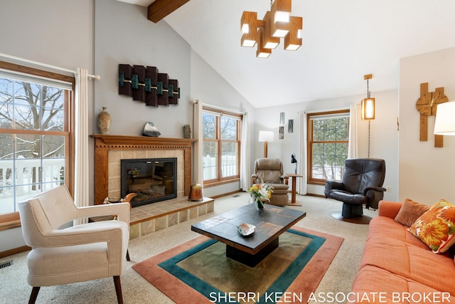 carpeted living room featuring a tile fireplace, plenty of natural light, beamed ceiling, and high vaulted ceiling