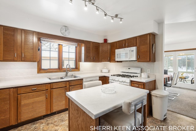 kitchen with sink, a kitchen island, and white appliances