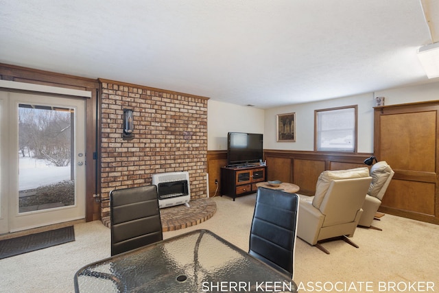 carpeted living room with heating unit and wood walls