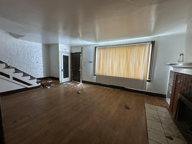 unfurnished living room featuring wood-type flooring and a fireplace