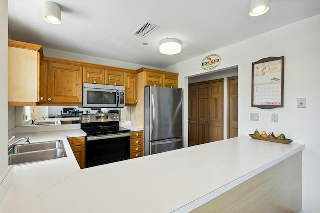 kitchen featuring kitchen peninsula, appliances with stainless steel finishes, and sink