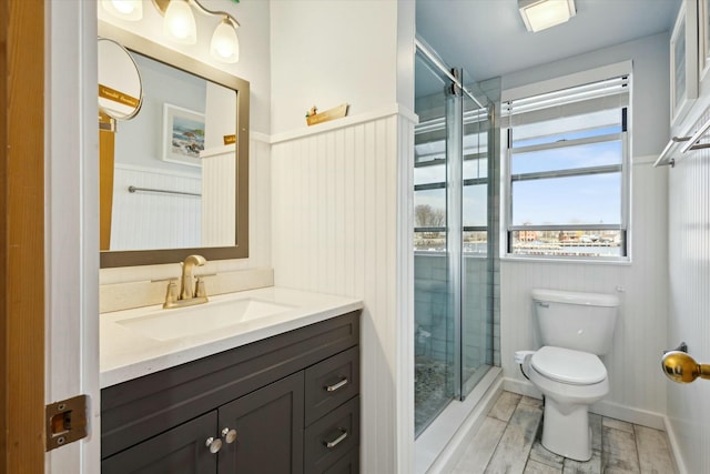 bathroom with vanity, toilet, and a shower with shower door