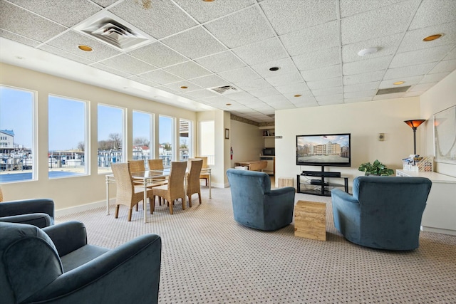 living room featuring carpet flooring and a drop ceiling