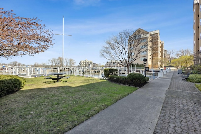 view of property's community featuring a lawn and a water view