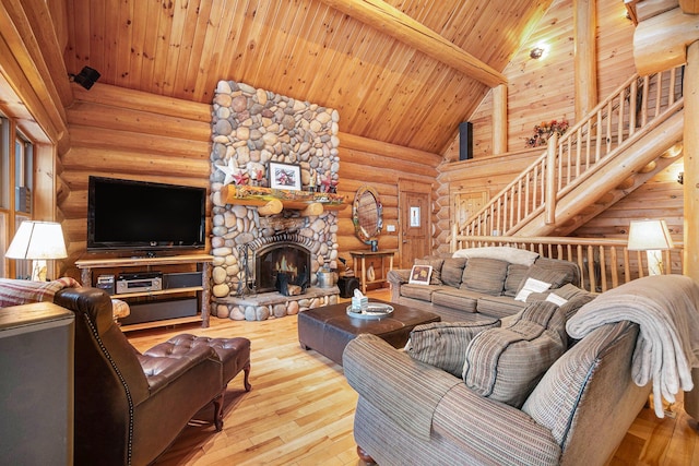 living room with a fireplace, high vaulted ceiling, log walls, wood ceiling, and beam ceiling