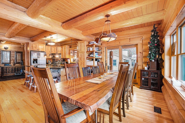 dining area with beam ceiling, light hardwood / wood-style flooring, and wood ceiling