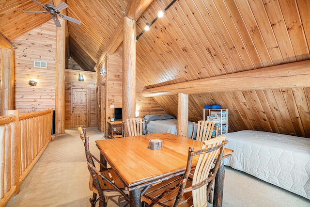 carpeted dining room featuring ceiling fan, beam ceiling, wooden walls, and wood ceiling