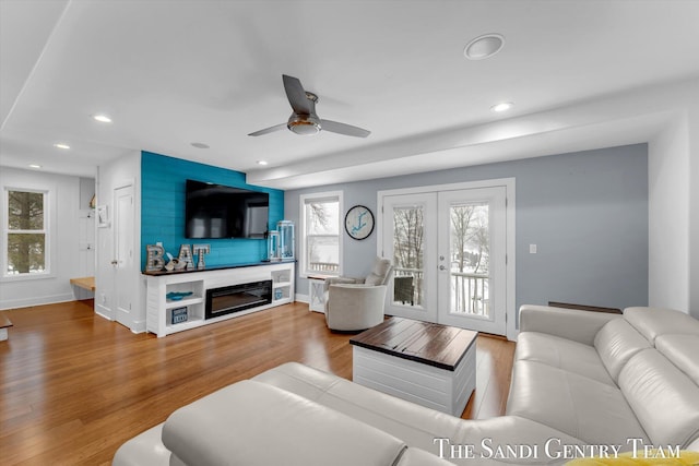 living room featuring a fireplace, french doors, hardwood / wood-style flooring, and ceiling fan