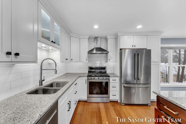 kitchen with white cabinetry, sink, wall chimney range hood, tasteful backsplash, and appliances with stainless steel finishes