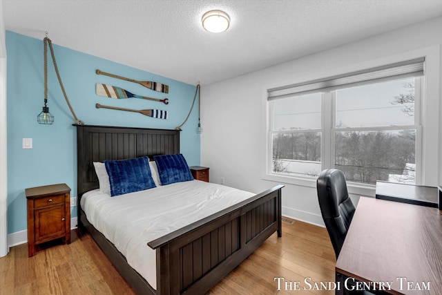 bedroom featuring light hardwood / wood-style floors and a textured ceiling