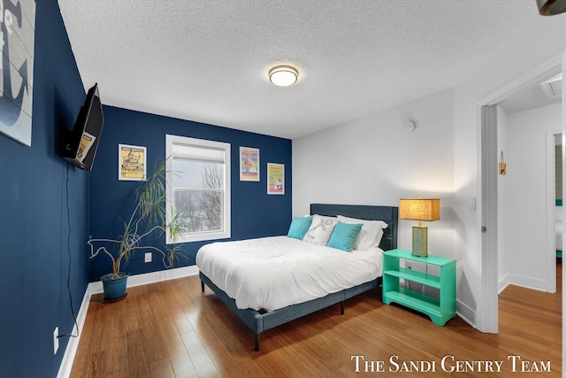 bedroom featuring hardwood / wood-style floors and a textured ceiling