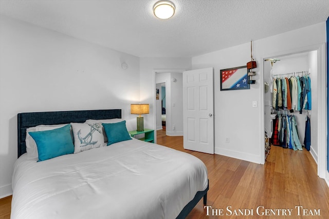 bedroom with hardwood / wood-style floors, a textured ceiling, and a closet