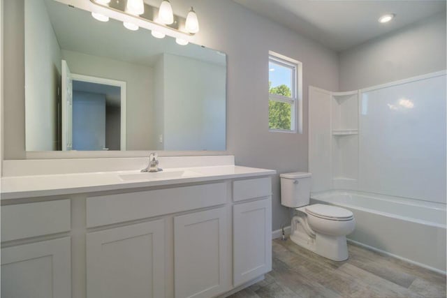 full bathroom with wood-type flooring, toilet,  shower combination, and vanity