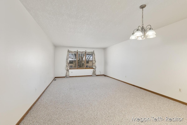 unfurnished room with a notable chandelier, carpet floors, and a textured ceiling