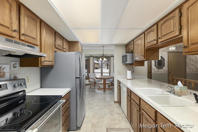 kitchen featuring pendant lighting, a notable chandelier, sink, and appliances with stainless steel finishes