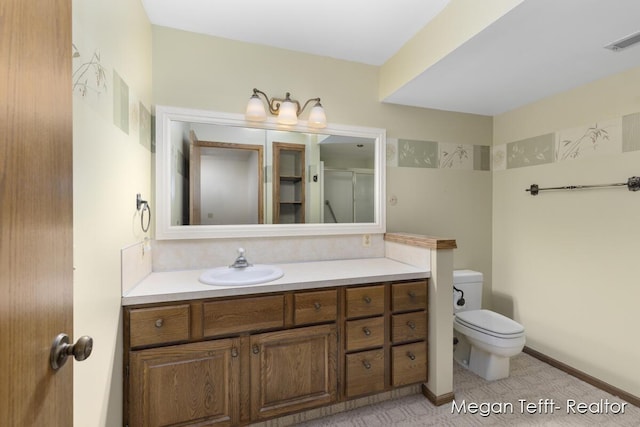 bathroom with vanity, toilet, and a shower with door