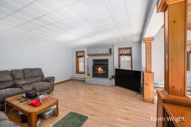 living room with baseboard heating, a fireplace, and light hardwood / wood-style floors