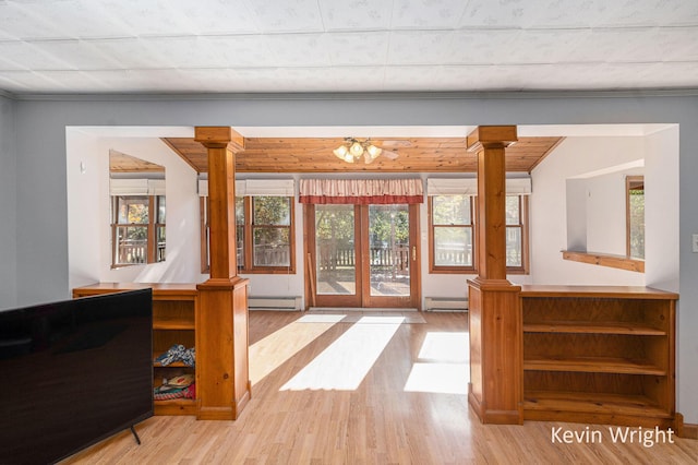 living room with light wood-type flooring, decorative columns, a baseboard radiator, and ceiling fan