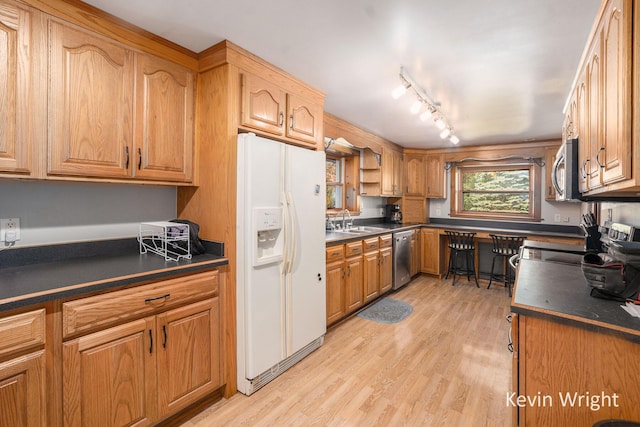 kitchen with light wood-type flooring, stainless steel appliances, rail lighting, and sink