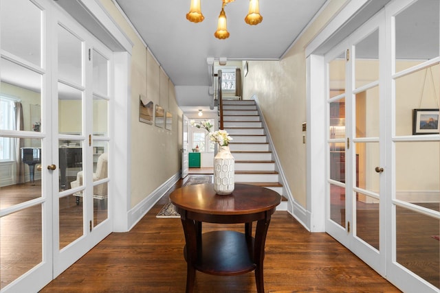 interior space featuring dark wood-type flooring, an inviting chandelier, and french doors