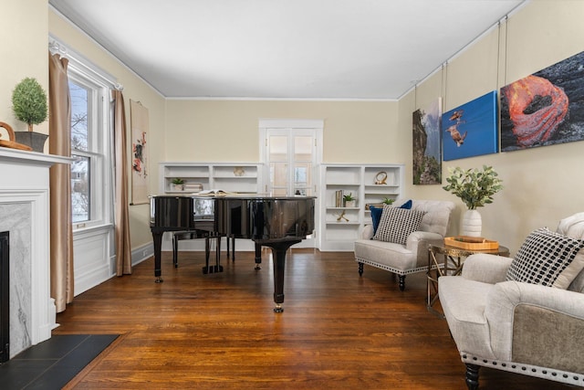 living area with a premium fireplace, crown molding, and dark hardwood / wood-style flooring