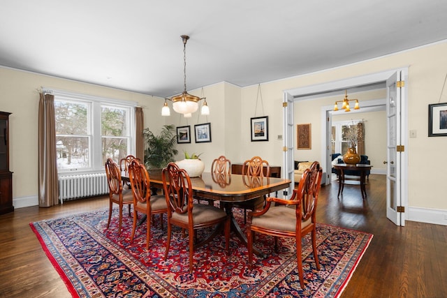 dining space with dark hardwood / wood-style flooring and radiator