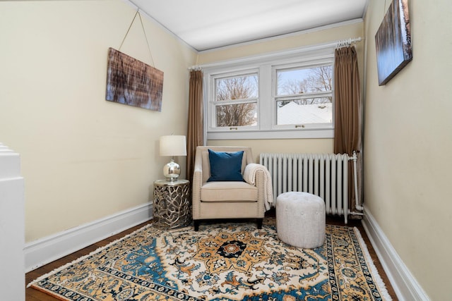 living area with radiator, crown molding, and wood-type flooring